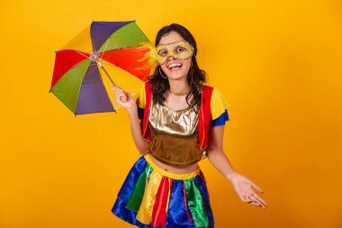 Karnaval kıyafetleri içinde, renkli şemsiyesi ve maskesi olan güzel Brezilyalı bir kadın. Hoş geldiniz..