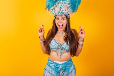 Mavi beyaz karnaval kıyafetleri içindeki güzel Brezilyalı kadın. Tüylü taç, şans dileyerek, gülümseyerek ve...