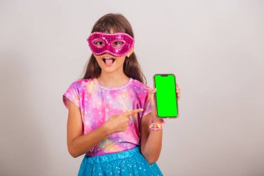 Brezilya 'daki karnaval için giyinmiş güzel Brezilyalı bir kız. Yeşil renkli ekranlı harika bir akıllı telefon..