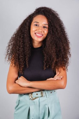 Dikey fotoğraf, güzel siyah Brezilyalı kadın, kameraya bakıyor, kıvırcık saçlı..