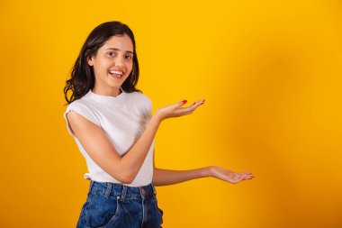 Güzel Brezilyalı kadın sağ tarafa bir şey sunuyor..