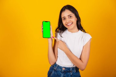 Güzel Brezilyalı kadın elinde akıllı telefon, yeşil renkli ekran gösteriyor..
