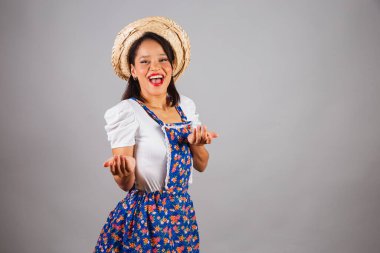 Brezilyalı kadın, kuzeydoğuda, Haziran partisi kıyafetleriyle, hasır şapkalı. Ellerinle davet et, çağır, gel..