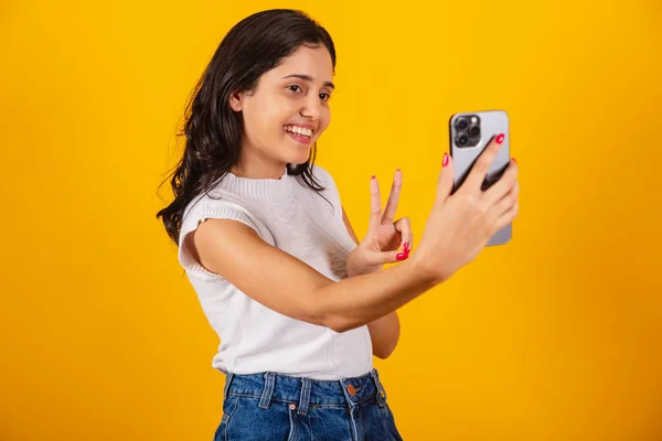 スマートフォンを手にした美しいブラジル人女性が自画像を撮り — ストック写真