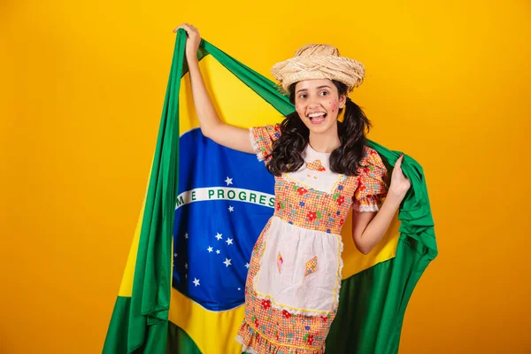 brazilian woman, with clothes of festa junina, with flag of brazil