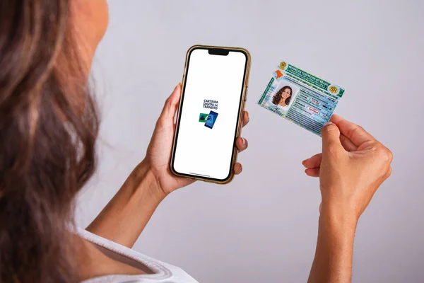 stock image hands holding driver's license and smartphone. Apps.