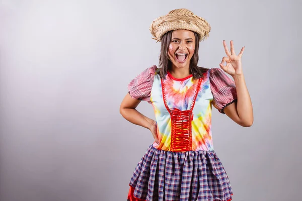 stock image Brazilian woman wearing country clothes, So Joo party, Junina party. ok sign with fingers. 