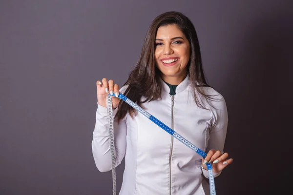 横写真 医療用のコートを着たブラジル人女性栄養士 テープの測定 — ストック写真