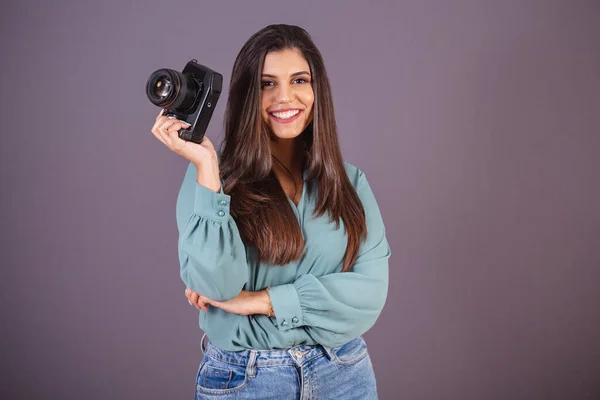 stock image Horizontal photo. Beautiful Brazilian woman, with casual clothes, Jeans and green shirt. female photographer holding photo camera.