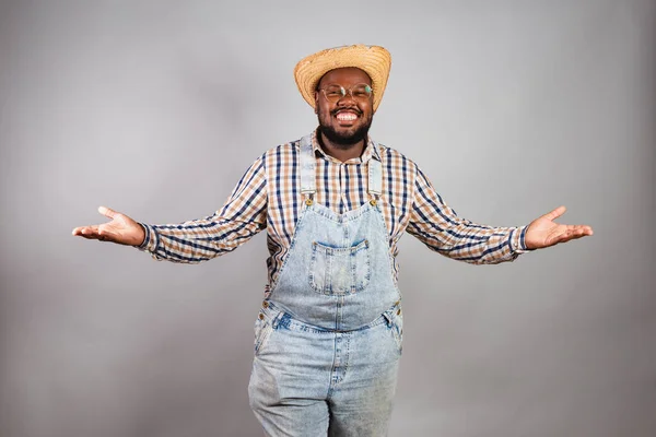 brazilian black man wearing country clothes from festa junina,festa de so joo. with open arms, welcome, welcoming.