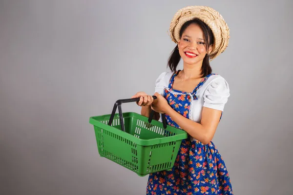 Brazilian woman, northeastern, with June party clothes, straw hat. holding market basket,shopping for So Joo party.