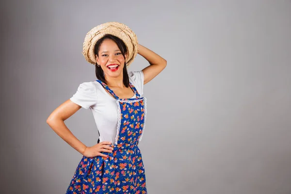 stock image Brazilian woman, northeastern, with June party clothes, straw hat. Hands on waist and hat.