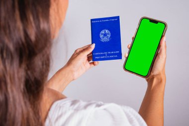 Çalışma kitabı ve akıllı telefon tutan eller. Resmi iş başvuruları, iş olanakları.