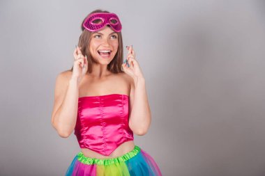Pembe karnaval kıyafetleri giymiş Brezilyalı sarışın kadın. Rimel, şans işareti, tezahürat. Dilek.