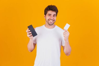 Cep telefonu ve kredi kartı olan genç yakışıklı bir adam uygulamayla alım yapıyor.