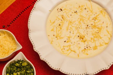 Lezzetli ve lezzetli Cassava çorbası, patates çorbası, rendelenmiş peynirli çorba, ve maydanoz, odunsu arka planda, et suyu, kış yemekleri.