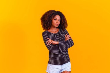 Sarı arka planda Afro kadın çapraz kollar