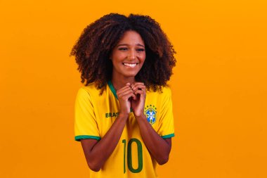Brezilyalı destekçi. Brezilyalı kadın taraftarlar futbol ya da futbol maçını sarı arka planda kutluyorlar. Brezilya renkleri.