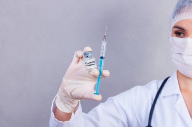 nurse holding covid 19 vaccine and syringe. Coronavac. Vaccination against the new Corona Virus Vacine-Covid19: A syringe being drawn up with Vacine-Covid 19.