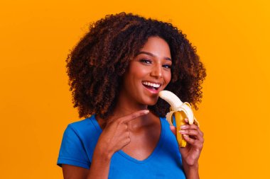 Muz yiyen genç afro kız. Sağlık konsepti. Sağlıklı beslenme