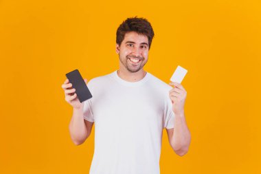 Cep telefonu ve kredi kartı olan genç yakışıklı bir adam uygulamayla alım yapıyor.