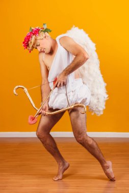 Sevgililer Günü konsepti. Aşk Tanrısı 'nın portresi - Sarı arka planda yay ve okla Aşk Tanrısı.