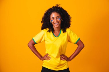 Brezilyalı bir hayran. Brezilyalı taraftar sarı arka planda futbol ya da futbol maçını kutluyor. Brezilya 'nın Renkleri.