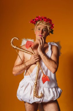 Sevgililer Günü konsepti. Aşk Tanrısı 'nın portresi - Sarı arka planda yay ve okla Aşk Tanrısı.