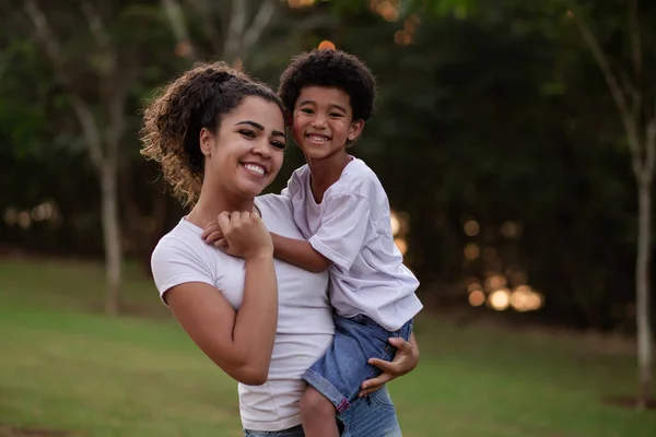 カメラで笑っている公園の母親とアフロの息子 — ストック写真