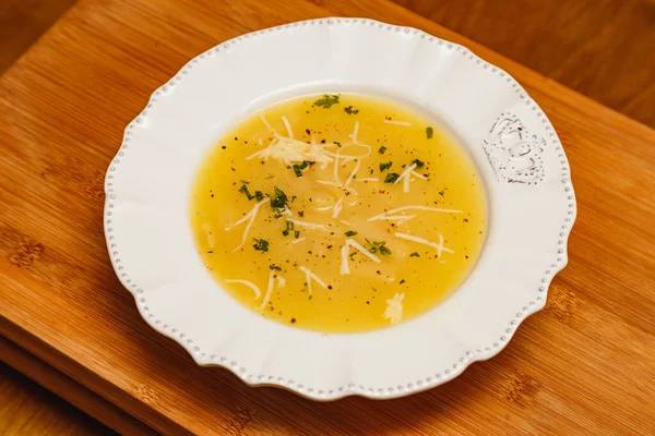 おいしいとおいしいキャッサバのスープ ジャガイモのスープ 上にすりおろしたチーズとスープ パセリ 木の背景に スープ料理 冬の食べ物 — ストック写真