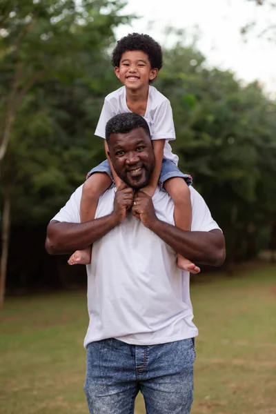 Afro Menino Com Seu Pai Parque Seu Pescoço — Fotografia de Stock