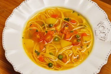 Sebzeli lezzetli şehriye çorbası, sebzeli şehriye çorbası, ahşap zemin üzerinde, kırmızı kumaş arka plan, tost, maydanoz ve parmesan, Brezilya kış yemekleri, gurme mutfağı.