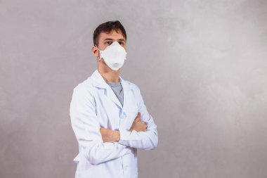 Korunaklı maskeli bir doktor, kolları mesajlaşmak için uzayda çaprazlanmış Coperid 19 'a karşı.