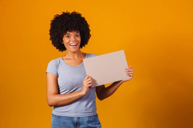 Kadın boş pano gösteriyor. Reklam panosu. Kara Cuma. Reklamcılık. Gülen kadının elinde boş reklam pankartı var. Mesajın için hazırım. İndirim ve indirim. Sezon satışları.