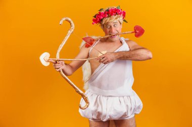 Sevgililer Günü konsepti. Aşk Tanrısı 'nın portresi - Sarı arka planda yay ve okla Aşk Tanrısı.