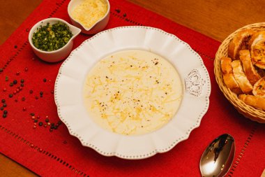 Lezzetli ve lezzetli Cassava çorbası, patates çorbası, rendelenmiş peynirli çorba, ve maydanoz, odunsu arka planda, et suyu, kış yemekleri.