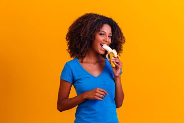 Muz yiyen genç afro kız. Sağlık konsepti. Sağlıklı beslenme