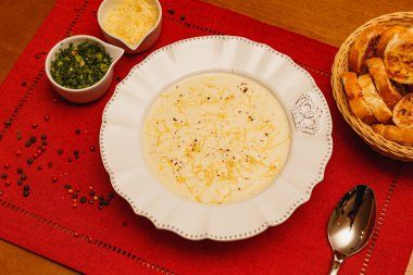 Lezzetli ve lezzetli Cassava çorbası, patates çorbası, rendelenmiş peynirli çorba, ve maydanoz, odunsu arka planda, et suyu, kış yemekleri.