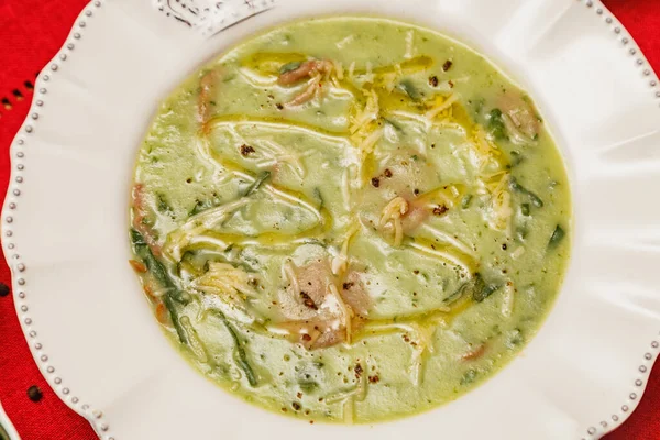 おいしいブロッコリーの緑のスープ 緑のブロッコリーのスープ ベジタリアン すりおろしたパルメザンチーズとパセリ 木製の背景と赤い生地 ブラジルの冬の食べ物 — ストック写真