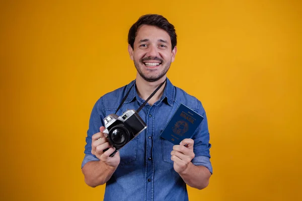 Lachende Knappe Toerist Met Een Paspoort Een Fotocamera Gele Achtergrond — Stockfoto
