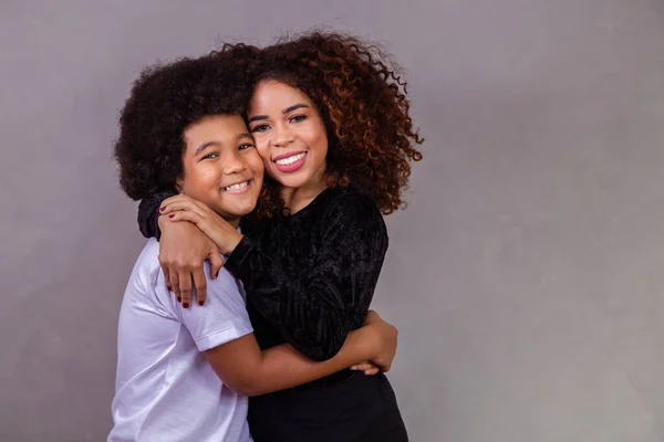 stock image black mother and son hugging on gray background