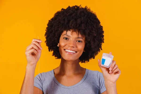 afro woman flossing her teeth. oral health concept