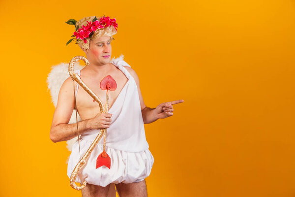 Valentine's day concept. Portrait of the God of love - Cupid with bow and arrow on a yellow background.