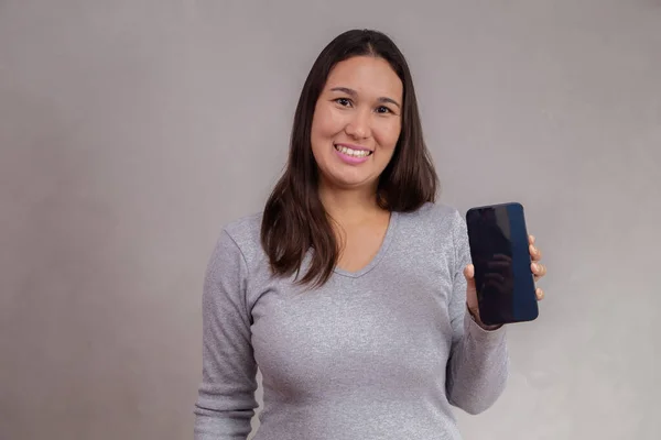Sorrindo Mulher Asiática Está Apontando Smartphone Enquanto Está Sobre Fundo — Fotografia de Stock