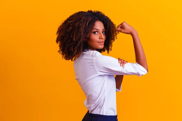 We can do it. Woman\'s fist of female power. Woman victim of racism. Abuse at work. The feminine power. Female empowerment. The strength of women. Yellow background.