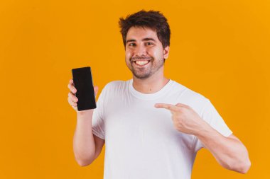 Elinde cep telefonu olan yakışıklı adam mesaj için yeri işaret ediyor.