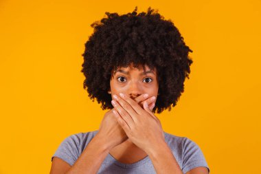 Sarı arka planda el ele tutuşan siyah kadın, taciz kavramı, feminist, ırkçılık ve önyargı.