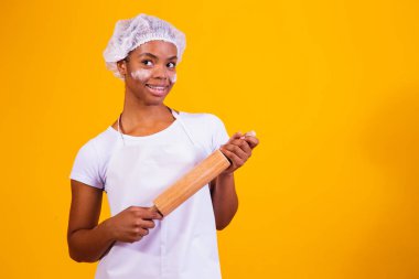 Sarı arka planda pizzacı kız elinde oklavayla.