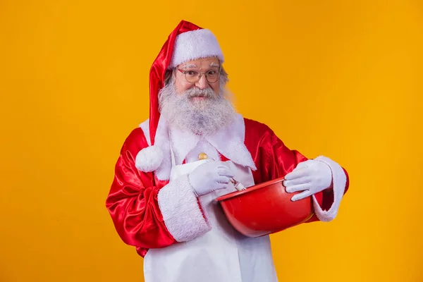 Święty Mikołaj Misą Bicie Ciasto Żółtym Tle — Zdjęcie stockowe