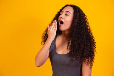 Siyah tenli güzel kadın sağlıklı dişler gülümsüyor güzel model cilt bakımına bakıyor. Kıvırcık saçlı Afro kadın